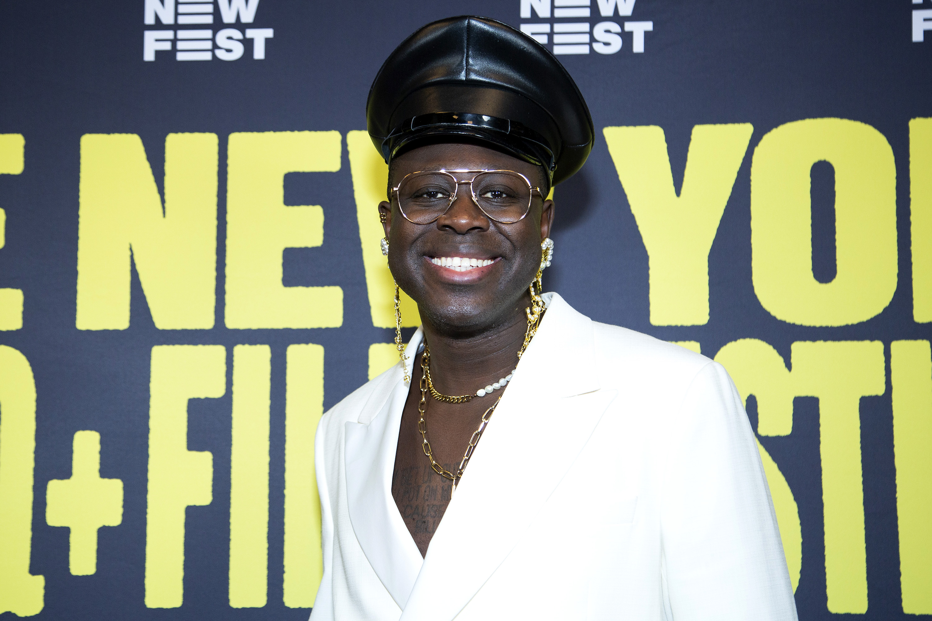 Bob the Drag Queen in a black leather hat with gold accessories