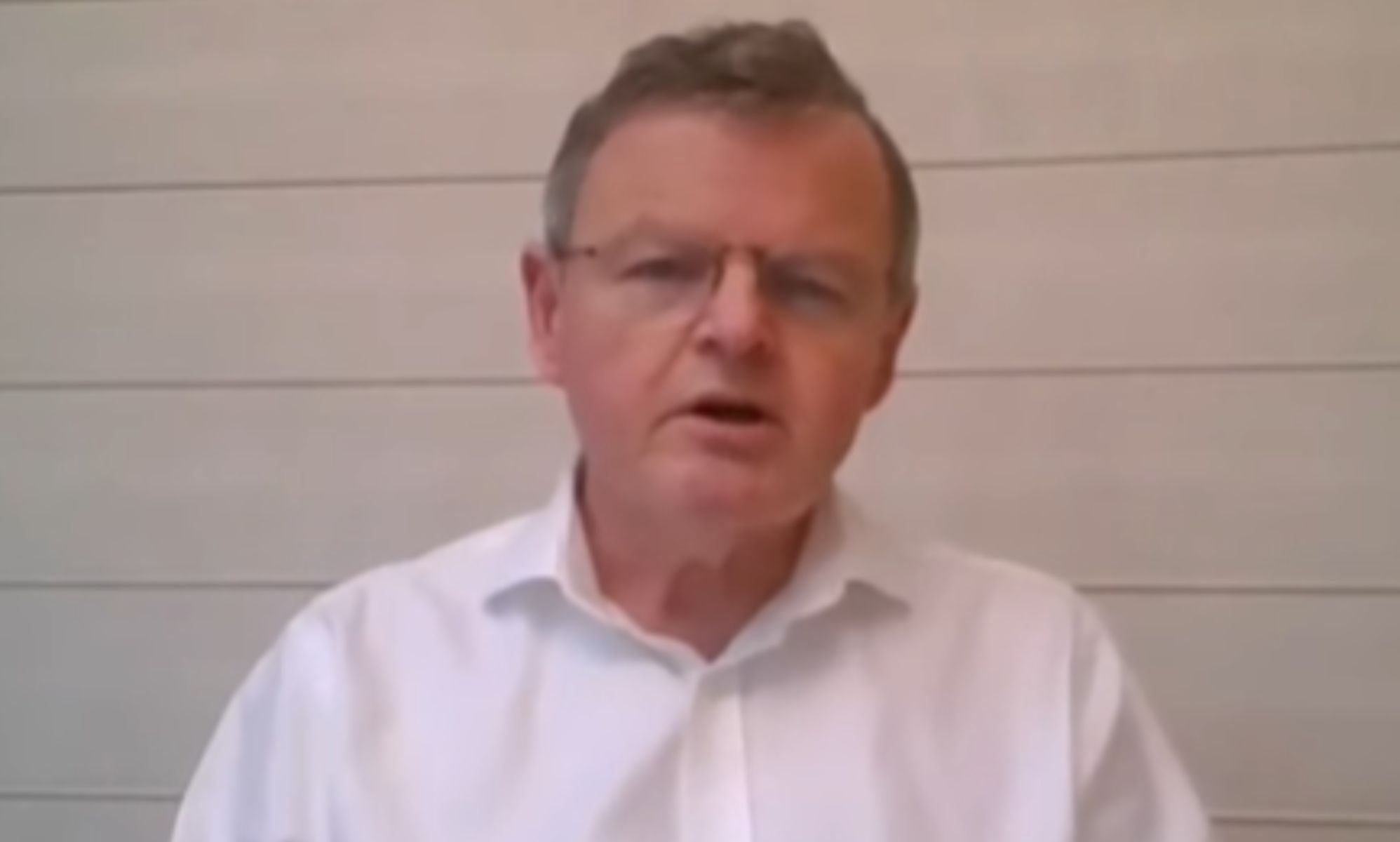 Dr David Levy, in a white shirt, speaking into a webcam.