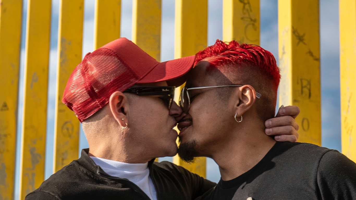 HIV-positive men hold kiss-in next to Trump's border wall for World AIDS Day