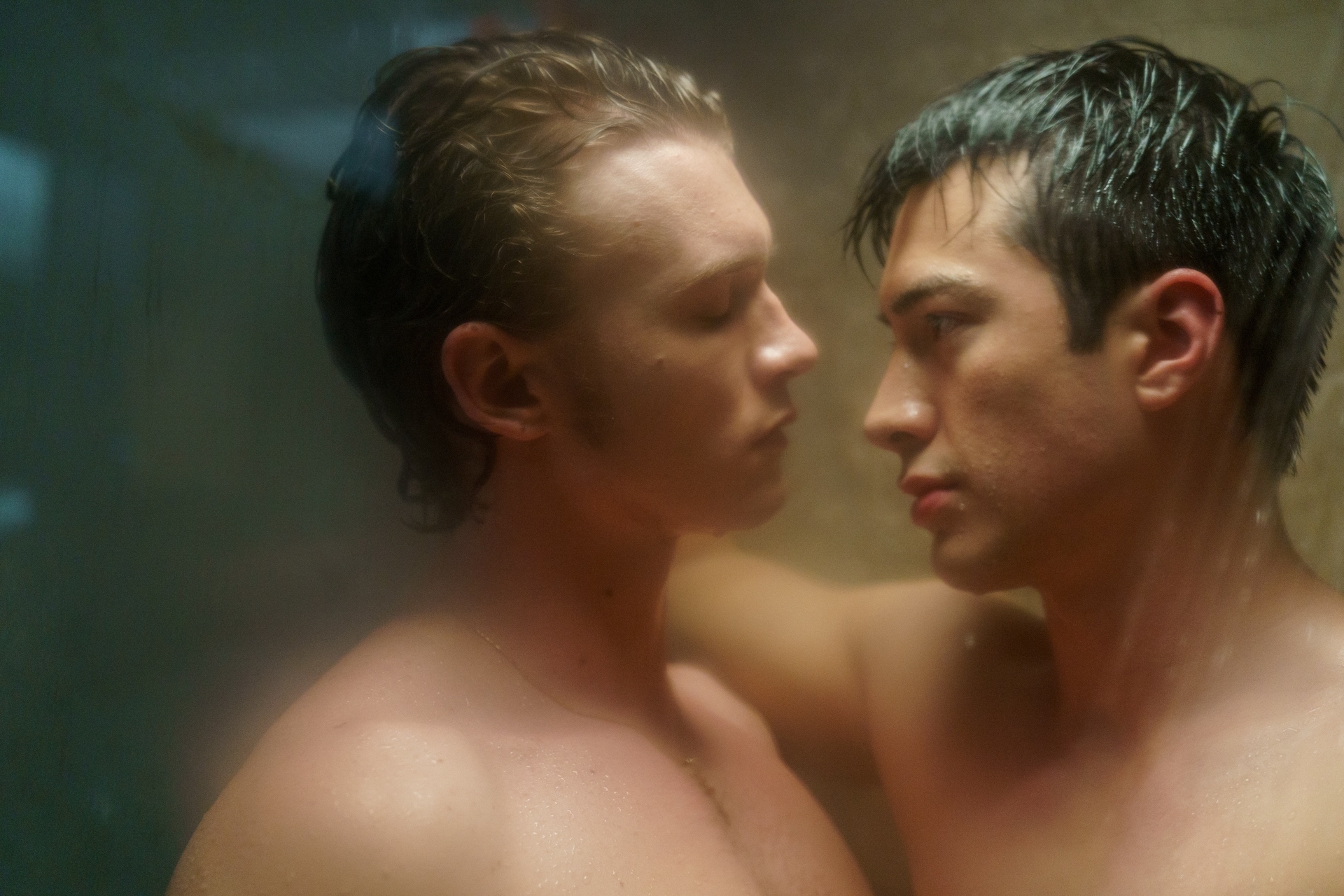 Heated Rivalry (L to R) - Connor Storrie as Ilya Rozanov and Hudson Williams as Shane Hollander. The pair are standing with their bodies pressed together in the shower.
