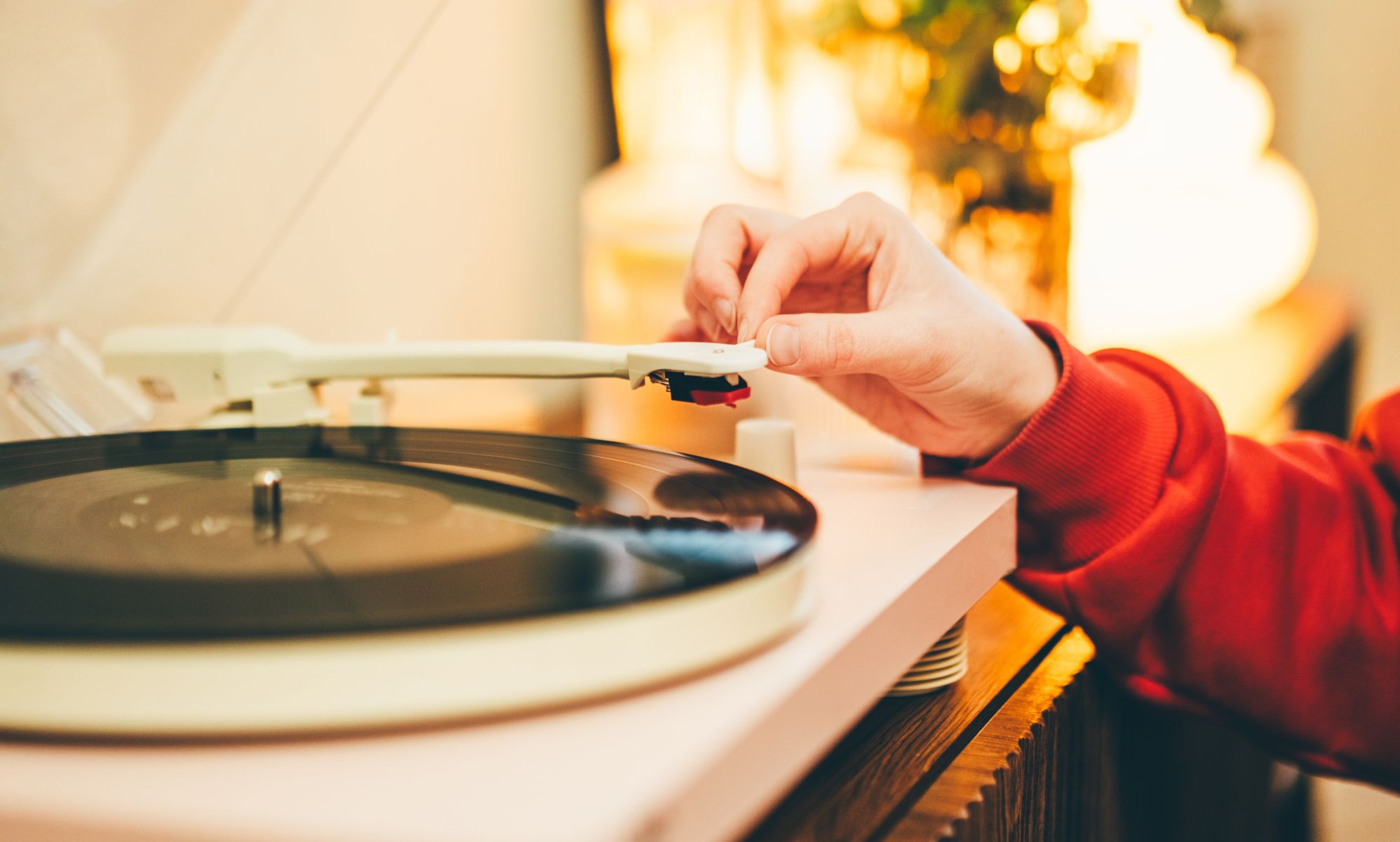 Someone holding the pin of a record player.