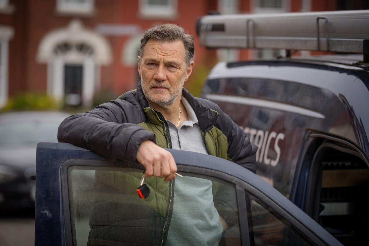 David Morrissey as Clive leaning up against a car door.