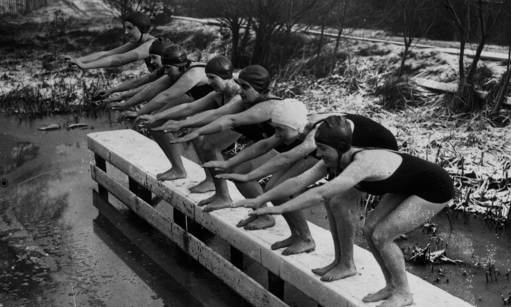 A photo from 1935 of women covered in snow preparing to dive into Kenwood Ladies
