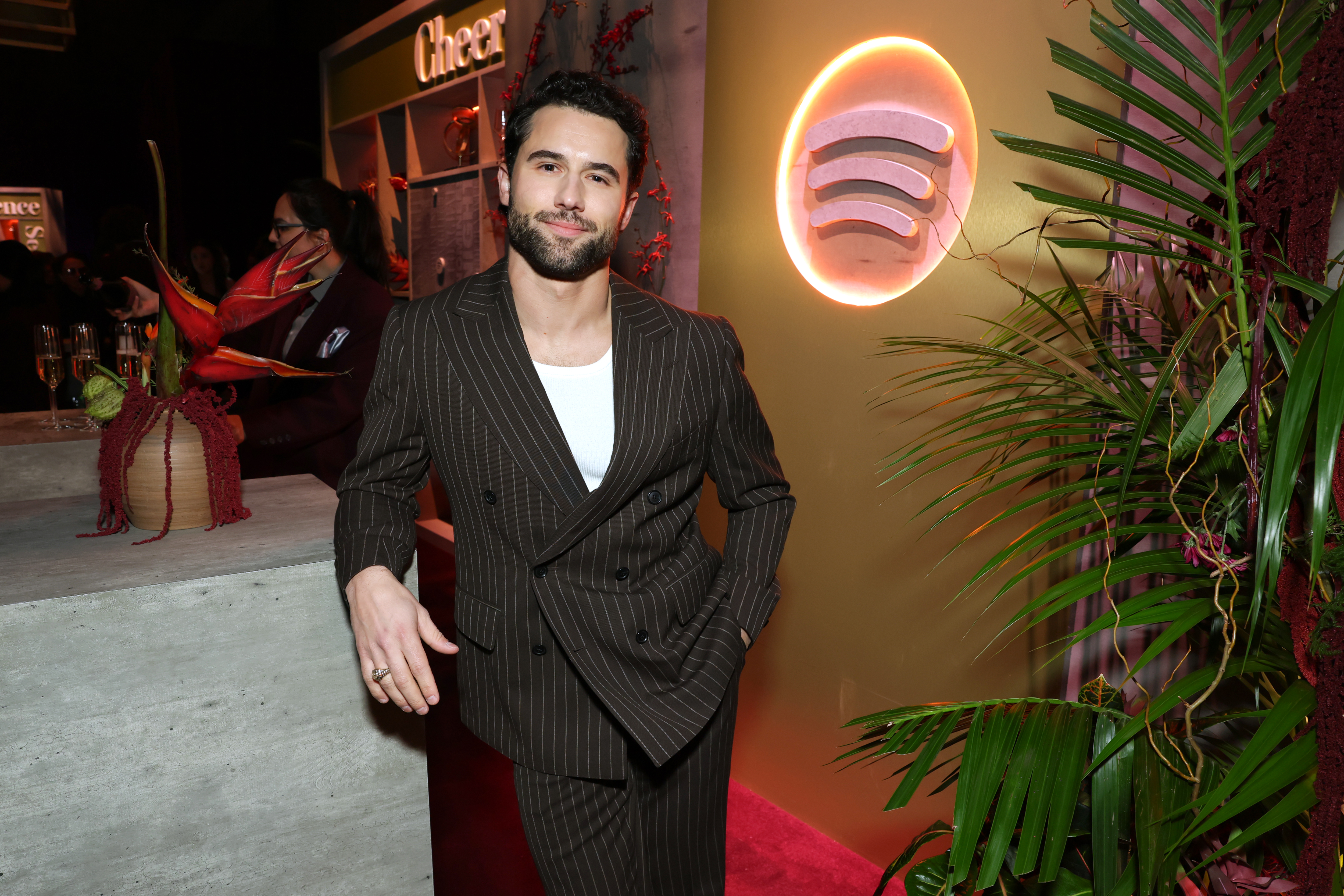 Robbie GK smiling in a dark brown pinstripe suit