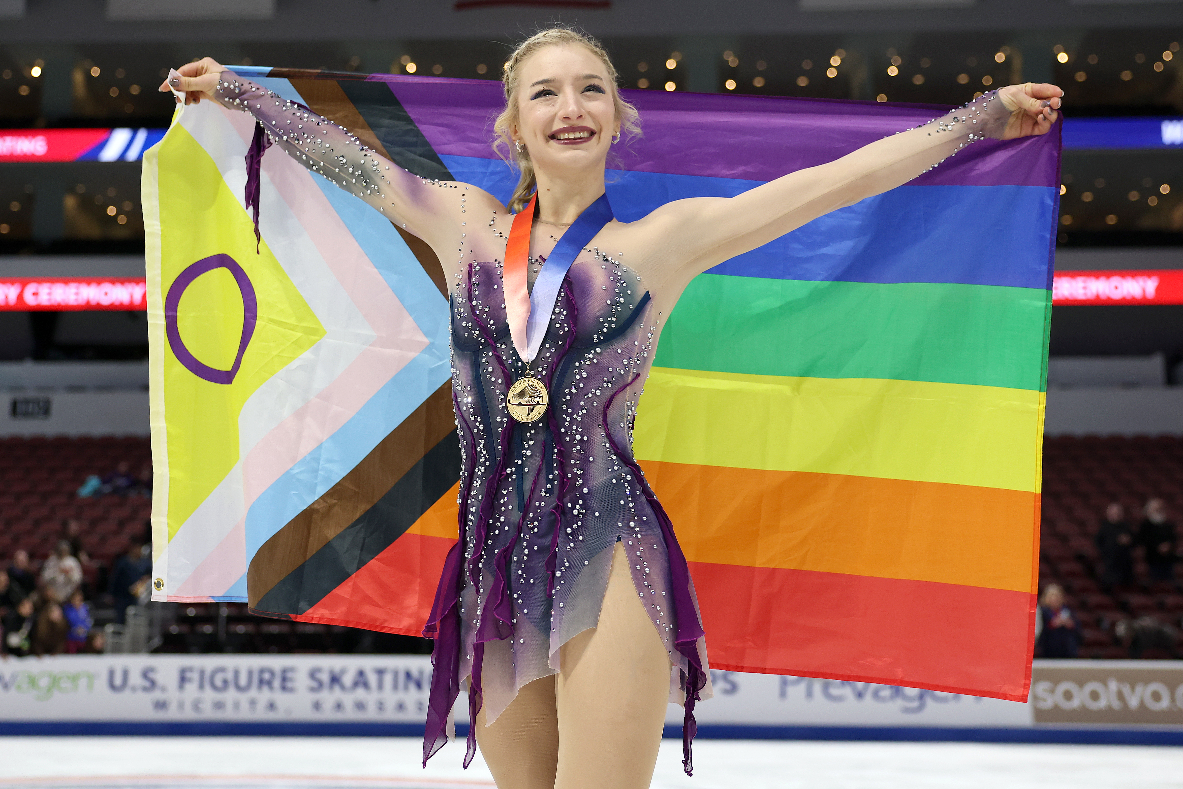 Amber Glenn poses with the gold medal and progress pride flag