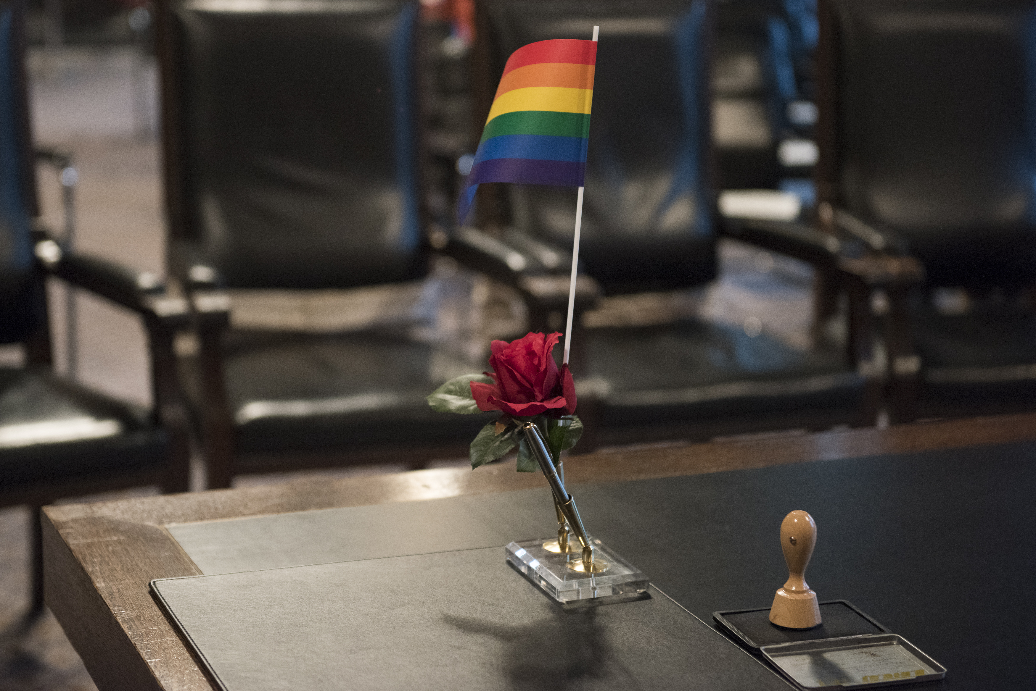 A rainbow flag stands on a court table